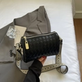 Detail der schwarzen geflochtenen Zylindertasche mit goldener Hardware und Ethno-Gurt - Schwarz