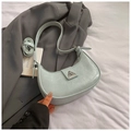 Detailed shot of mint green crescent bag with glossy texture and silver buckle - Blue
