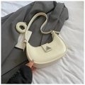 Close-up of beige crescent moon bag featuring wrinkled leather texture and metal buckle - White