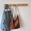Brown lychee leather crescent shoulder bag with round charm and slim shoulder strap - Brown
