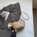 Chic beige faux leather crossbody bag with white plush doll charm and gold logo detail - Khaki With Pendant