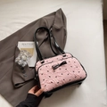 Borsa tote rosa con trama plissettata e fiocchi neri sopra un blazer grigio - Rosa
