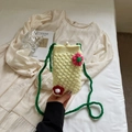 Dettaglio della borsa gialla all'uncinetto con fiori e chiusura con una grande perla - Beige