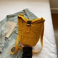 Detailopname van gele nylon crossbodytas met gespsluiting tegen een casual lifestyle decor - Geel