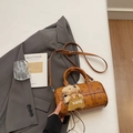 Dettaglio della borsa Boston marrone con motivo a orsetti e ciondolo in peluche su letto - Con Ciondolo / Marrone