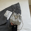 Detail der silbergrauen Beuteltasche mit Schmetterling und Perlenanhänger auf einem Anzug - Silber