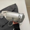 Close-up of metallic silver baguette bag with Paris embossing and adjustable strap - Silver