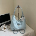 Blue nylon crescent bag with bow and heart charm on desk with laptop and gear - Blue with Pendant