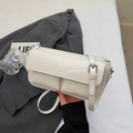 Detail of minimalist beige baguette bag with PARIS embossing and silver metal buckle - Off White
