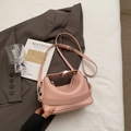 Detail view of the pink lychee leather texture and silver buckle on a minimalist handbag - No Pendant / Pink