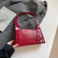 Chic red structured handbag featuring polished silver studs and wide shoulder strap - Red