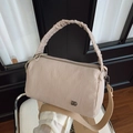 Dettaglio borsa Boston in nylon rosa chiaro con manico a pieghe e logo argento su sedia - Bianco Sporco