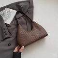 Nahaufnahme der dunkelbraunen geflochtenen Hobo-Tasche mit Schutzfüßen und feinem Riemen - Braun