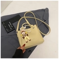 Detailed view of yellow litchi pattern bucket bag with fashion print and pearl doll charm - Yellow with Pendant