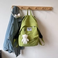 Close-up of light green nylon backpack with white logo patch and cute plush bear charm - With Pendant / Green