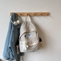 Detailansicht des beigen Nylon-Rucksacks mit Bärenanhänger und Aufnäher-Stickerei - Mit Anhänger / Gebrochenes Weiß