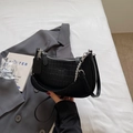 Detailansicht der schwarzen Baguette-Tasche mit Krokomuster und silberner Metallkette - Schwarz