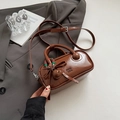 Bolso Boston marrón caramelo brillante con dije de lazo y correa ajustable - Marrón