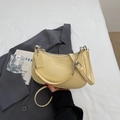 Detail der cremefarbenen Baguette-Tasche mit Krokostruktur und silberner Kette - Gelb
