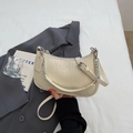 Detailansicht der cremefarbenen Baguette-Tasche mit Kroko-Prägung und Silberkette - Cremeweiß
