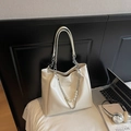 Creamy white high-gloss tote bag with pearl chain and fashion label on soft bedding - White