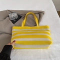 Bolso tote tejido a rayas amarillas y blancas con asas finas en escena de estilo de vida - Amarillo