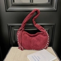 Dettaglio della borsa a mezzaluna in camoscio rosso scuro con rivetti argentati e cuore - Borgogna