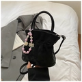Detailaufnahme einer schwarzen Plissee-Beuteltasche mit lila Perlen- und Blumenanhänger - Schwarz Mit Anhänger