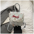 Detail van lichtblauwe tas met kantafwerking, rode strikken en hartvormige hanger - Kant Strikprint Stijl / Blauw