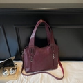 Detail of burgundy leather tote bag with silver zippers and laptop lifestyle backdrop - Burgundy