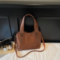 Detail of dark brown tote bag with premium lychee grain texture and metal zipper pockets - Brown