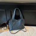 Detailed close-up of blue faux leather tote bag showing grainy texture and silver zippers - Blue