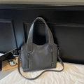 Detail of grey tote bag with wrinkled texture, vertical zippers, and adjustable strap - Gray