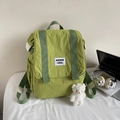 Detail of light green canvas backpack with plush bear charm and textured fabric finish - With Charm / Green