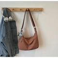 Detalle de bolso hobo marrón rojizo con colgante de estrella y correa en percha - Marrón