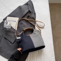 Detail van de blauwe en grijze patchwork denim emmer tas met bruine kunstleren handgrepen - Blauw