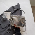 Close-up of metallic silver mini square bag with chain strap and balloon dog charm - Silver with Charm
