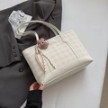 Dettaglio della borsa tote a scacchi bianco panna con ciondolo a forma di orsetto di peluche - Bianco Sporco