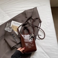 Mini dark brown glossy leather bucket bag with silver balloon dog charm and thin strap - Brown