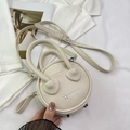 Dettaglio borsa rotonda beige con trama litchi e rivetti metallici sul fondo - Bianco Sporco