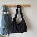 Primer plano del bolso de tela negra con detalle de correa rizada estilo nube suave - Negro