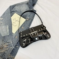 Detalle del bolso bajo el brazo de charol negro con remaches plateados y hebillas metálicas - Negro