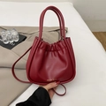 Minimalist pleated bucket bag in deep red leather with elegant gold brand logo detailing - Red