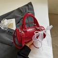 Detail view of red glossy patent leather Boston bag with pearl lace charm and logo - With Pendant / Burgundy
