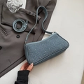Details einer hellblauen Jeans-Umhängetasche mit Silbernieten und Trageriemen - Blau