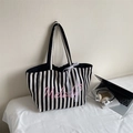 Dettaglio della borsa tote in tela a righe con stampa Melody rosa e fiocco in pizzo - Nero