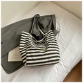 Detalle del bolso tote de lona a rayas blancas y negras con placa de logo dorada - Negro