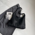 Minimalistische schwarze Shopper-Tasche mit Leder-Lychee-Struktur und breitem Gurt - Schwarz