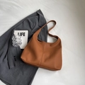 Detailed macro view of the brown litchi grain texture on this vintage hobo shoulder bag - Brown