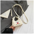 Close-up of mini bucket bag featuring cute bear embroidery and cream checkerboard texture - White